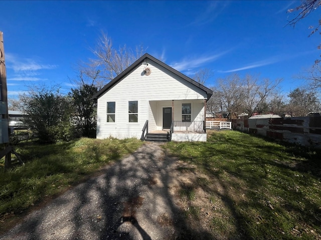 rear view of house with a porch and a yard