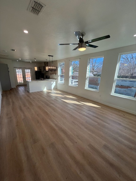 unfurnished living room featuring ceiling fan and wood-type flooring