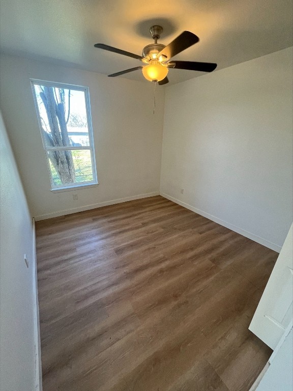 unfurnished room with dark hardwood / wood-style flooring and ceiling fan