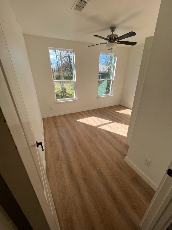 empty room with ceiling fan and light wood-type flooring