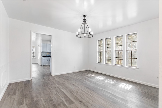 unfurnished room featuring dark hardwood / wood-style floors and an inviting chandelier