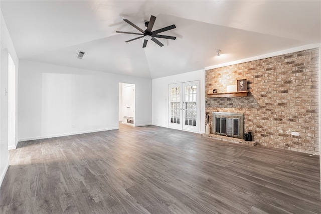 unfurnished living room featuring brick wall, dark hardwood / wood-style floors, a brick fireplace, ceiling fan, and vaulted ceiling