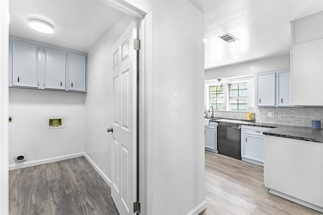 kitchen with dishwasher, light wood-type flooring, and tasteful backsplash