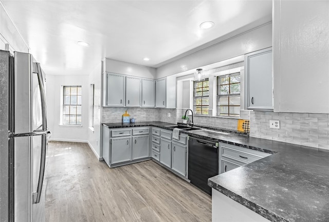 kitchen with stainless steel fridge, a healthy amount of sunlight, light hardwood / wood-style floors, and sink