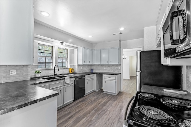 kitchen featuring hardwood / wood-style flooring, black appliances, white cabinets, backsplash, and sink