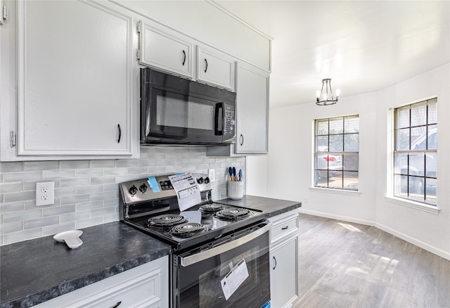 kitchen with a notable chandelier, stainless steel range with electric cooktop, white cabinetry, and light wood-type flooring