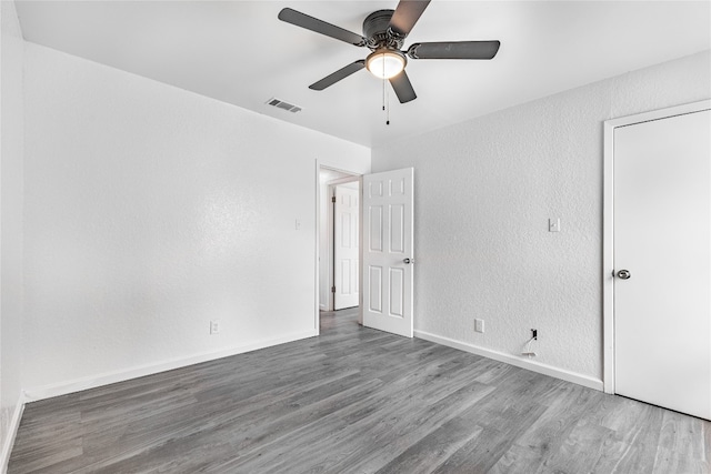 spare room featuring dark wood-type flooring and ceiling fan