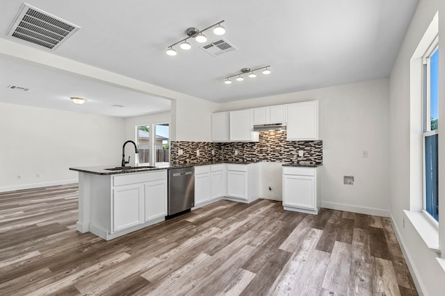 kitchen with white cabinetry, dishwasher, sink, kitchen peninsula, and hardwood / wood-style flooring