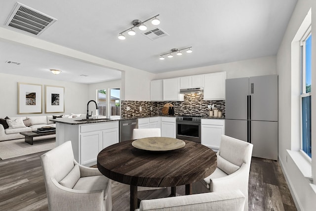 kitchen with white cabinets, sink, appliances with stainless steel finishes, and tasteful backsplash