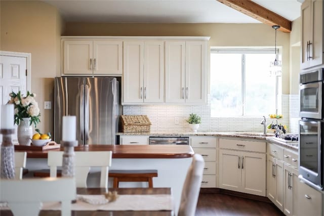 kitchen featuring appliances with stainless steel finishes, white cabinets, beamed ceiling, and backsplash