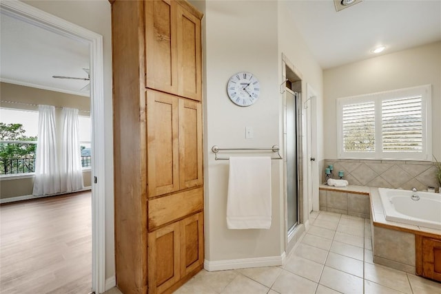 full bath featuring a stall shower, tile patterned flooring, baseboards, and a bath