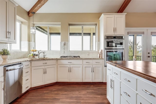 kitchen featuring white cabinetry, dark wood-style floors, tasteful backsplash, and appliances with stainless steel finishes