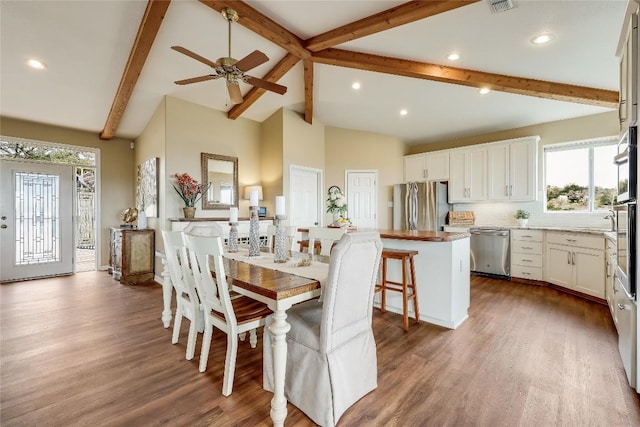 dining room with a ceiling fan, recessed lighting, lofted ceiling with beams, and wood finished floors