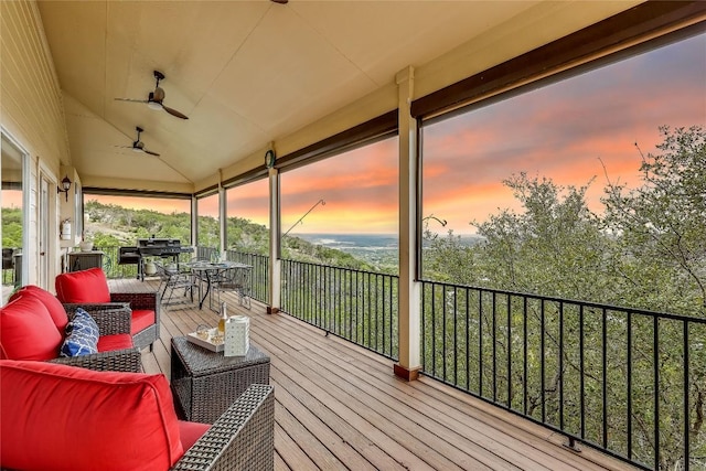 deck at dusk featuring ceiling fan and outdoor lounge area