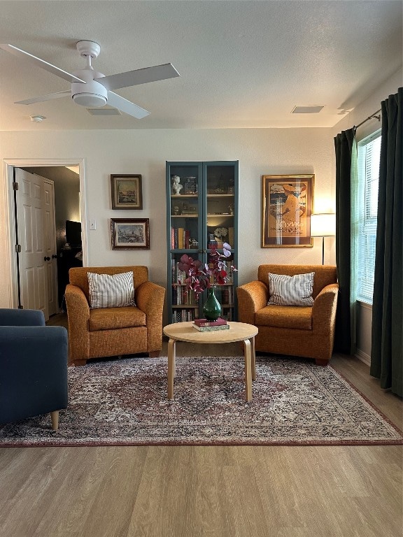 living room with a textured ceiling, hardwood / wood-style floors, and ceiling fan