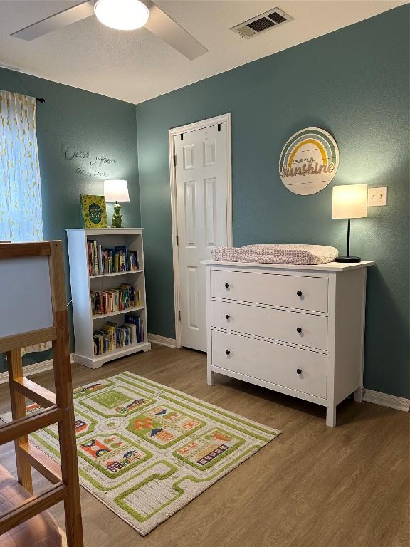 1301 NE 2nd St, Smithville, TX 78957 - bedroom featuring wood finished floors, baseboards, ceiling fan, and visible vents