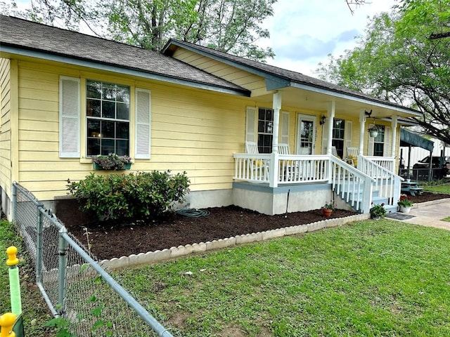 1301 NE 2nd St, Smithville, TX 78957 - ranch-style house featuring a shingled roof, fence, a front lawn, and a porch