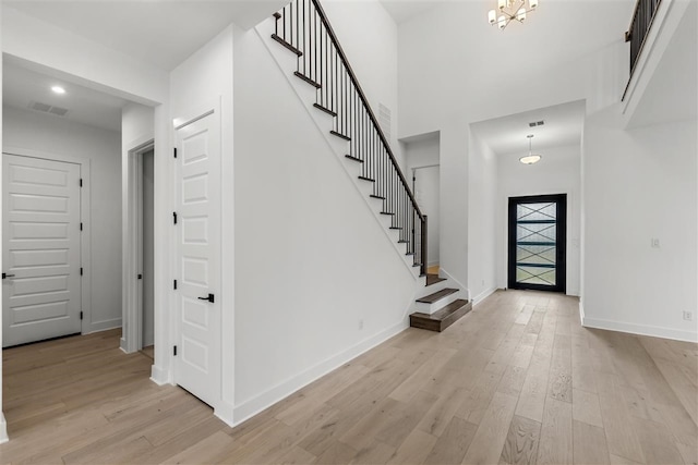 entrance foyer with light hardwood / wood-style floors and an inviting chandelier