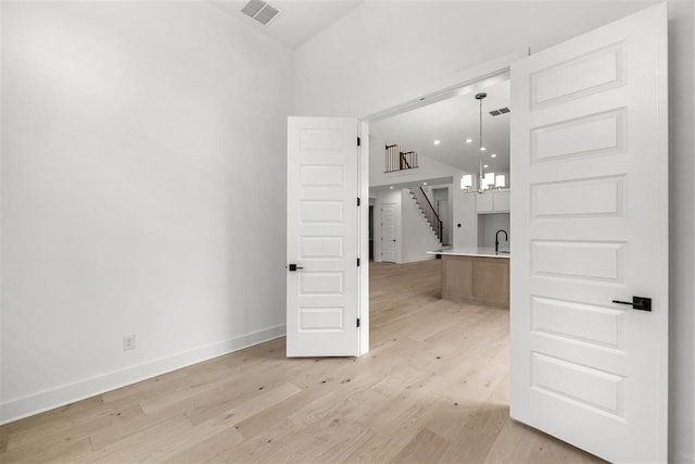 interior space featuring a chandelier, light hardwood / wood-style flooring, and sink