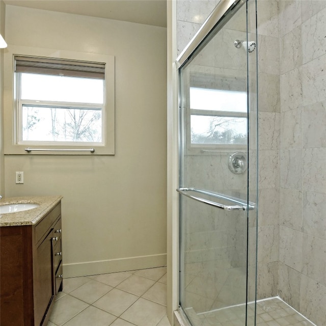 full bathroom featuring a stall shower, tile patterned flooring, baseboards, and vanity