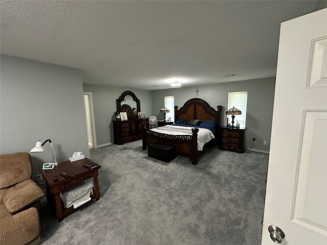 bedroom with a textured ceiling and dark colored carpet