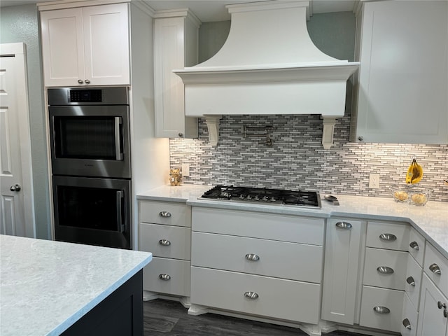 kitchen featuring white cabinets, appliances with stainless steel finishes, dark hardwood / wood-style floors, and premium range hood