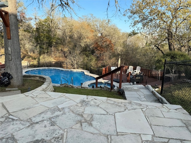 view of swimming pool featuring a wooden deck and a patio area