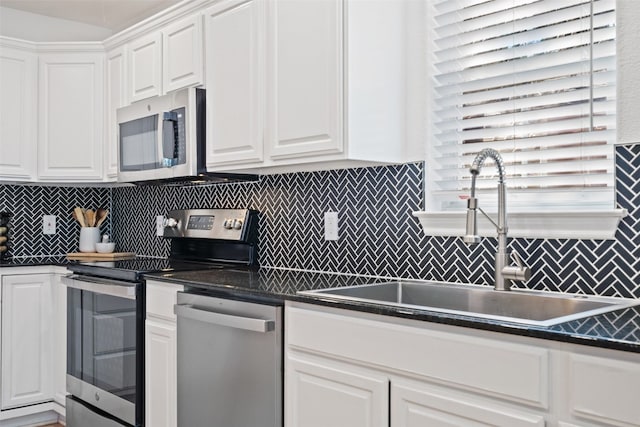 kitchen with tasteful backsplash, sink, white cabinets, and stainless steel appliances