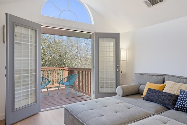 interior space with plenty of natural light, lofted ceiling, and light hardwood / wood-style flooring