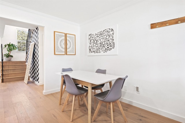 dining room featuring light hardwood / wood-style flooring and ornamental molding