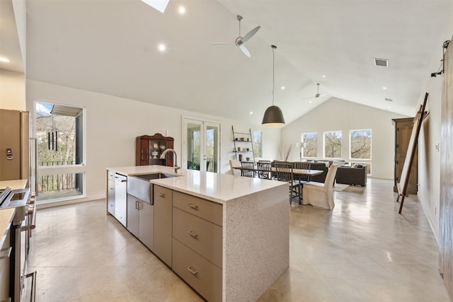 kitchen with appliances with stainless steel finishes, an island with sink, pendant lighting, ceiling fan, and sink