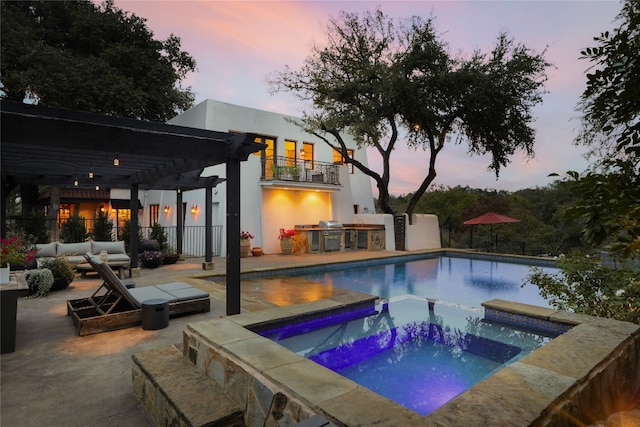 pool at dusk featuring a patio, a pergola, an in ground hot tub, and grilling area