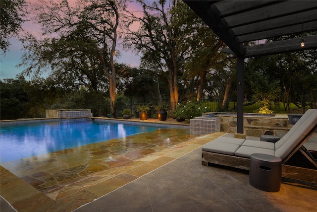 pool at dusk with a patio