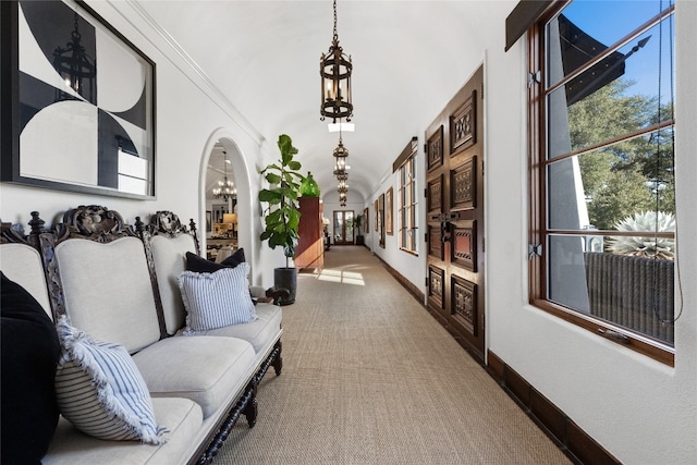 interior space with carpet flooring, a notable chandelier, and crown molding