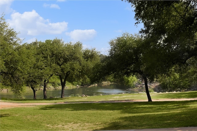 view of home's community with a water view and a yard