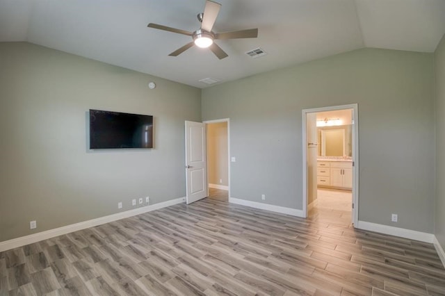 unfurnished bedroom with ensuite bath, light hardwood / wood-style floors, ceiling fan, and vaulted ceiling