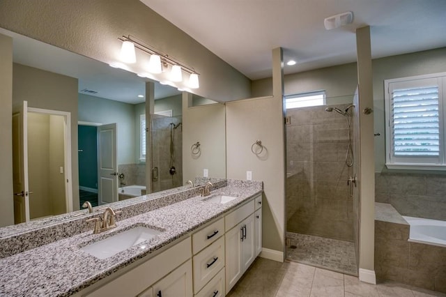 bathroom featuring independent shower and bath, vanity with extensive cabinet space, dual sinks, and tile floors