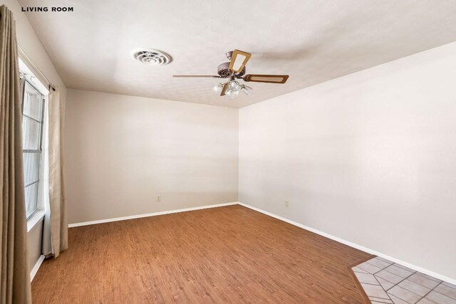 empty room with hardwood / wood-style floors, ceiling fan, and a healthy amount of sunlight