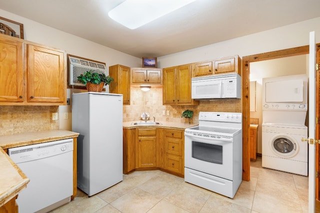 kitchen with white appliances, light tile patterned floors, backsplash, sink, and stacked washer / dryer