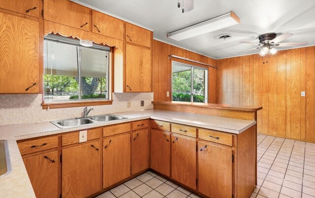 kitchen featuring ceiling fan, sink, light tile patterned floors, and kitchen peninsula