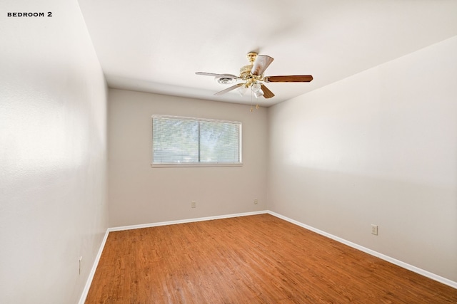 spare room featuring hardwood / wood-style floors and ceiling fan