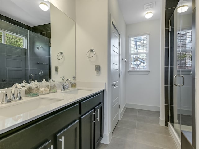 bathroom featuring dual vanity, tile flooring, plenty of natural light, and walk in shower