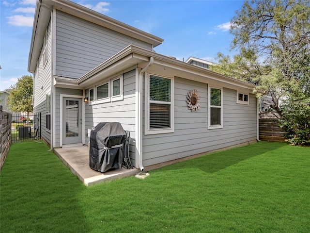 rear view of house featuring a yard, central AC, and a patio