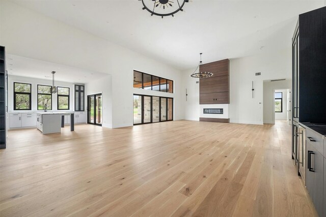 living room featuring an inviting chandelier, sink, and light wood-type flooring