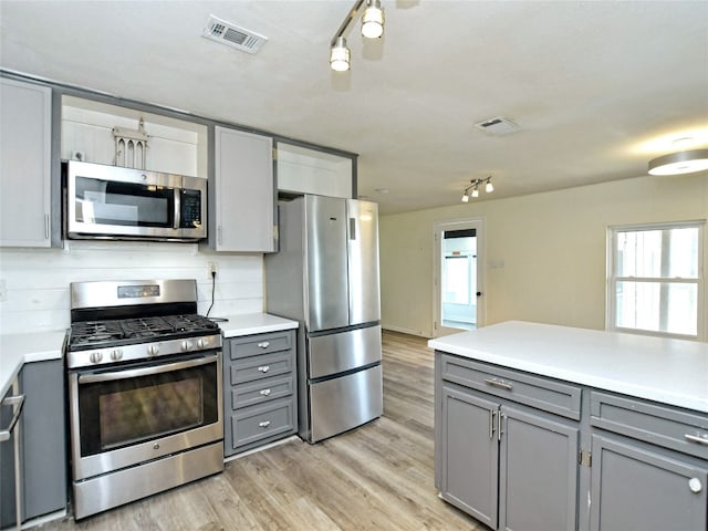 kitchen with light hardwood / wood-style flooring, stainless steel appliances, and gray cabinets