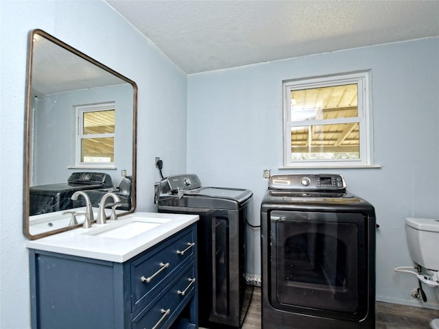 laundry area featuring dark wood-type flooring, a textured ceiling, sink, washer and clothes dryer, and hookup for an electric dryer