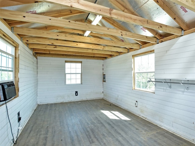 spare room featuring dark hardwood / wood-style flooring, vaulted ceiling with beams, and a wealth of natural light