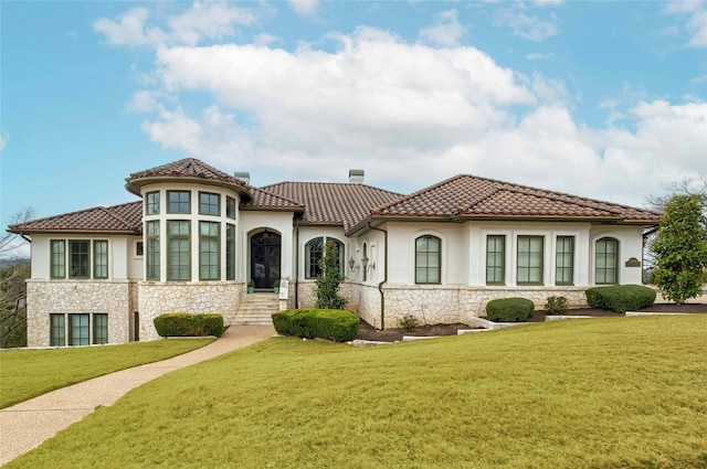 mediterranean / spanish-style home with a front lawn