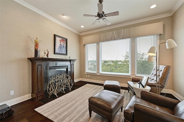 living area with ceiling fan, ornamental molding, and dark wood-type flooring