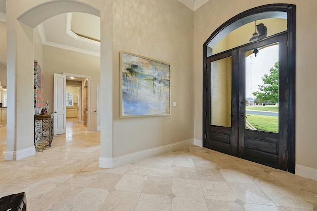 tiled foyer entrance with ornamental molding, french doors, and a wealth of natural light